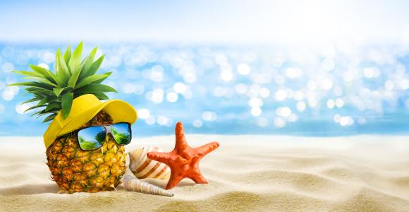 Pineapple with sunglasses and starfish enjoying a sunny beach day.